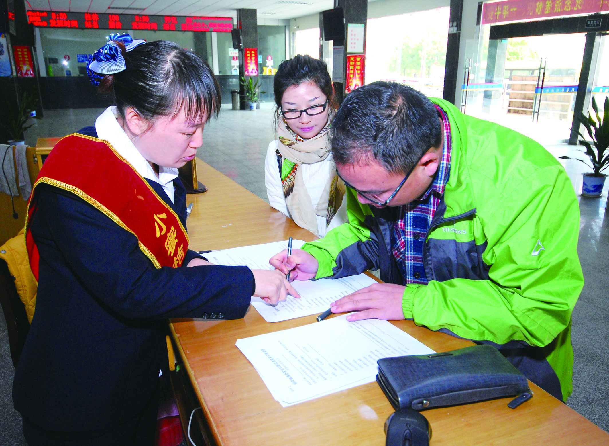 圖為洞口汽車總站站務(wù)人員在熱心為旅客服務(wù)。